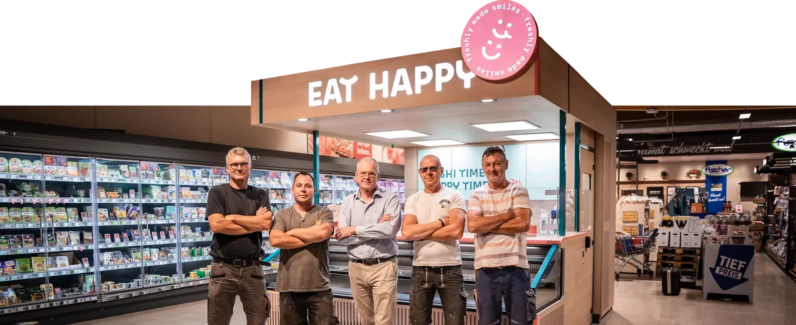 Foto des Kernteams von Laden Eins vor einem fertig gebauten EAT HAPPY Shop