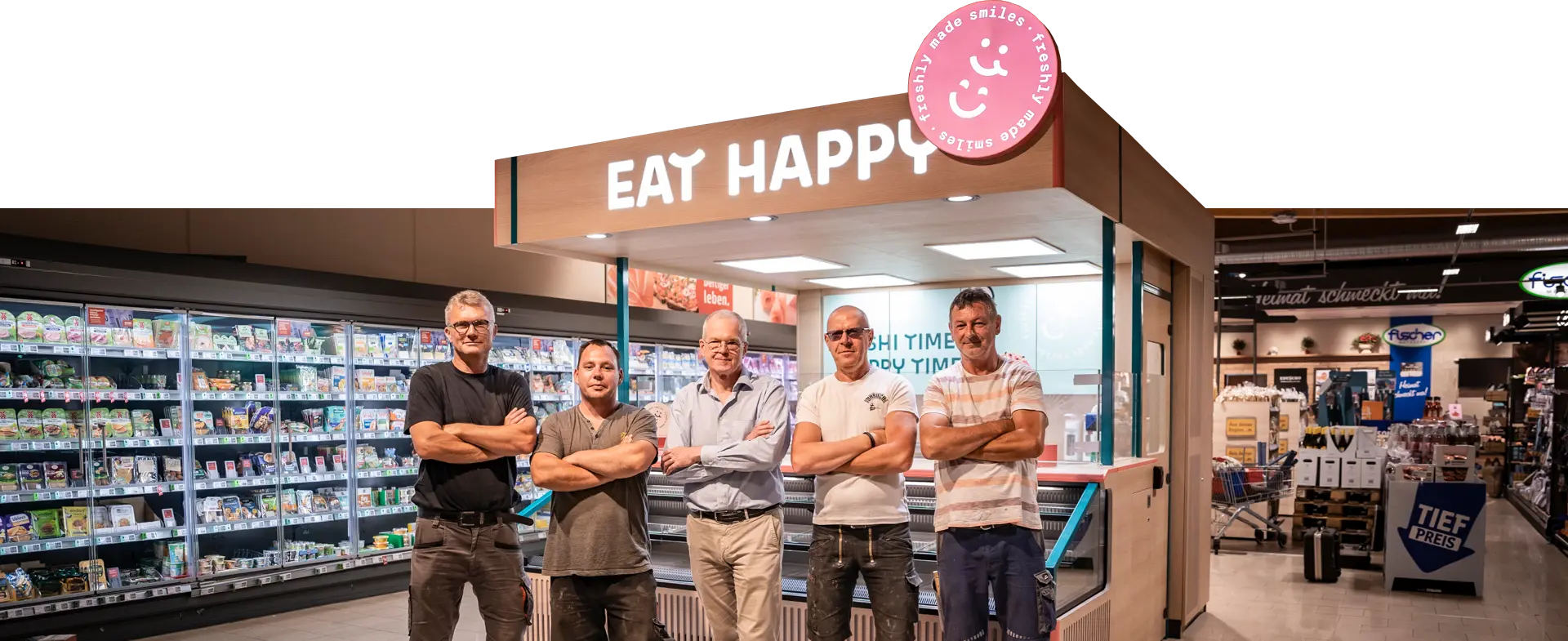 Foto des Kernteams von Laden Eins vor einem fertig gebauten EAT HAPPY Shop